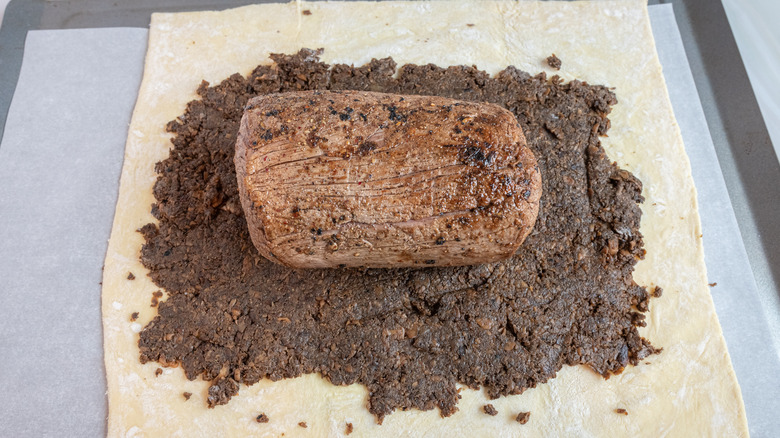 Unwrapped beef Wellington on baking sheet