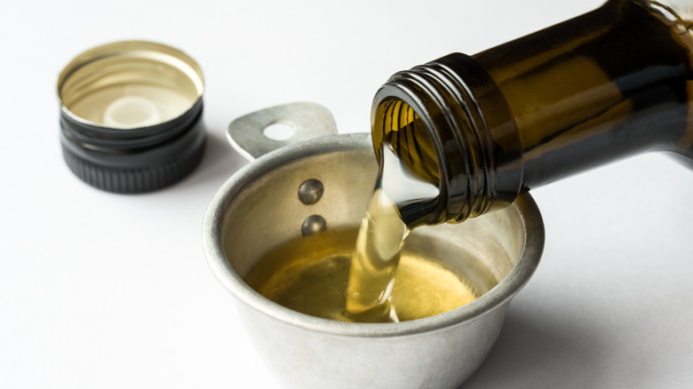 pouring oil into measuring cup