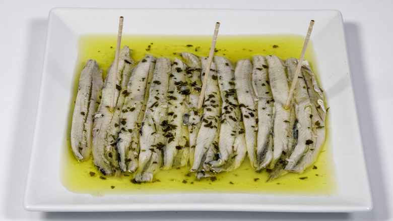 Anchovies on plate of oil