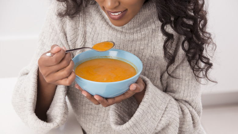 woman eating soup with spoon