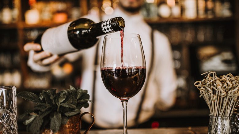 bartender pours wine