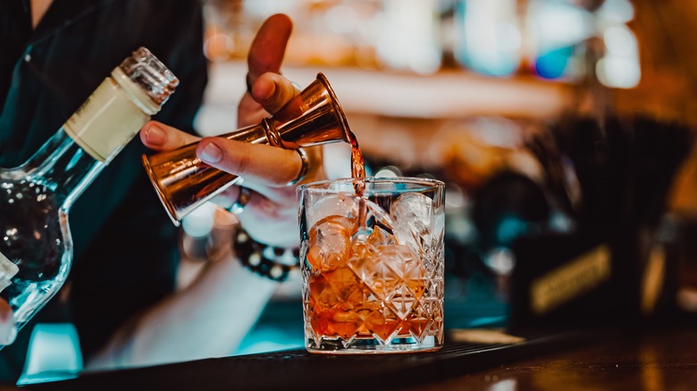 bartender makes Negroni cocktail