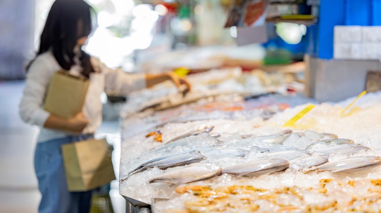 woman buying seafood in market