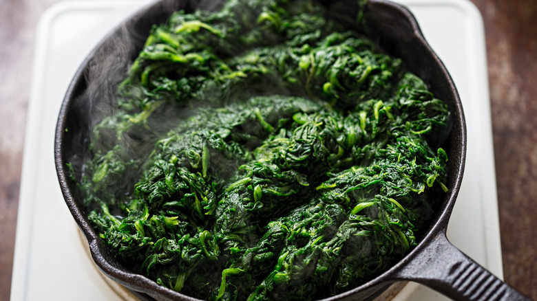 Frying thawed frozen spinach in pan