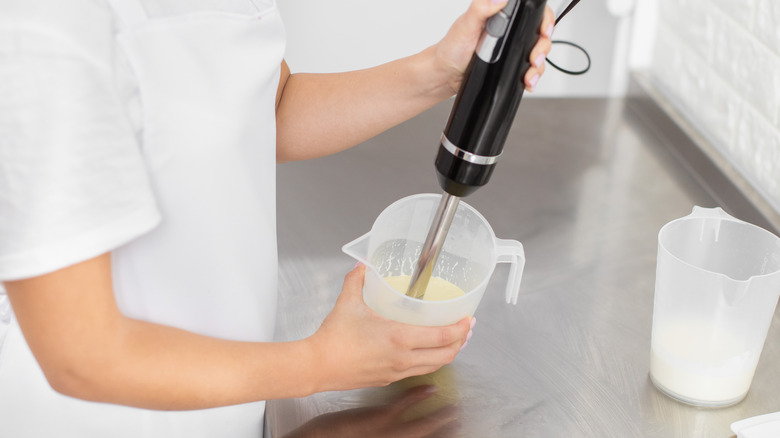 Chef using immersion blender to make cream