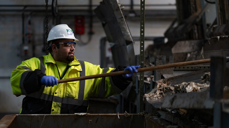 Sewage treatment worker cleans fatberg from pipes