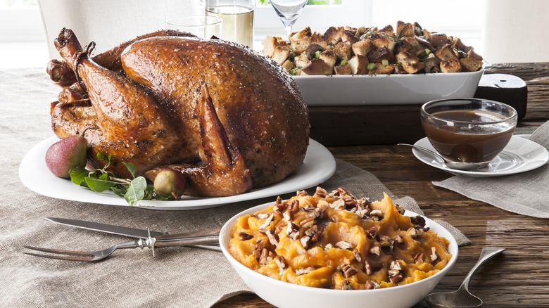 Thanksgiving table spread with turkey, stuffing, and potato casserole