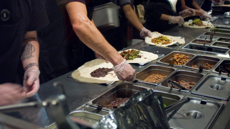 workers making Chipotle burritos