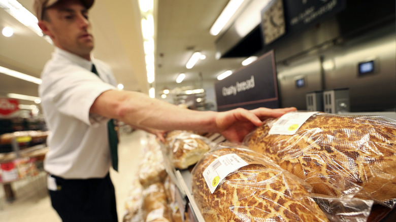 Man arranging loaves of bread