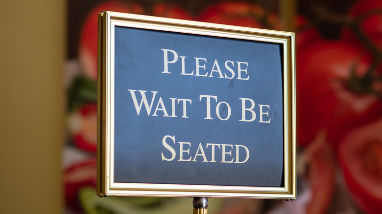 Please wait to be seated sign