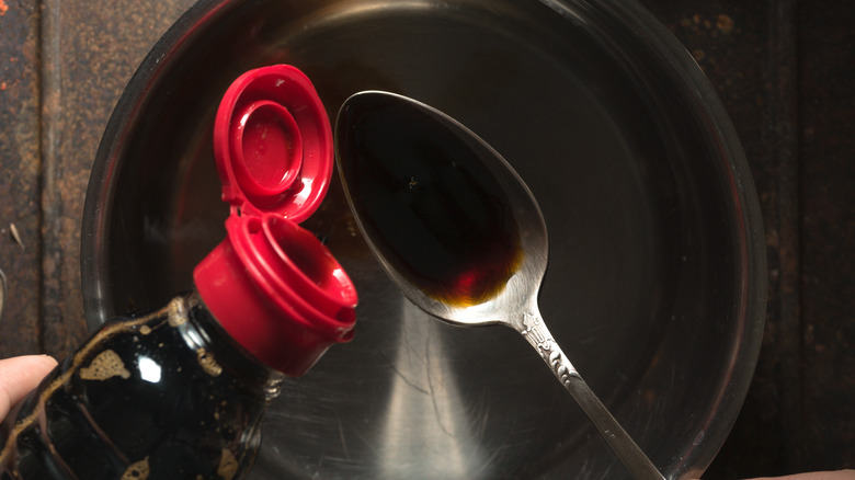 pouring soy sauce in pan