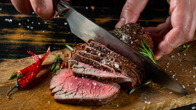 Person cuts steak with knife