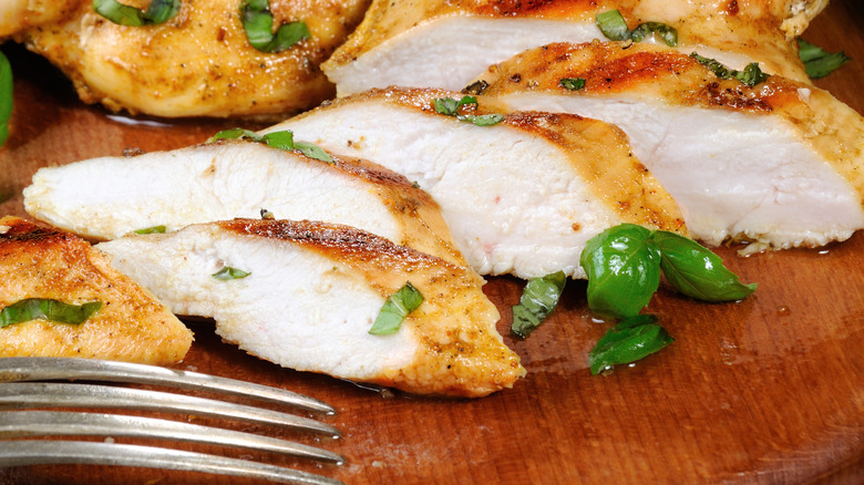 Juicy chicken breasts on a rustic cutting board