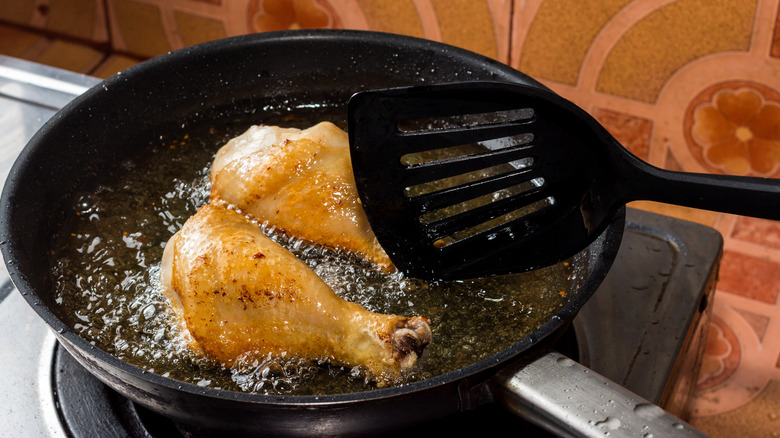 chicken thighs cooking in oil