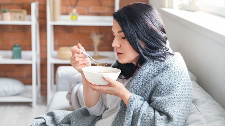 Sick woman eating soup