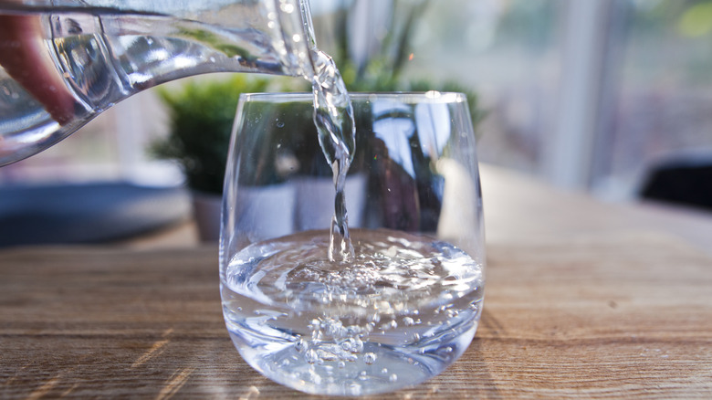 filling cup with water from a carafe