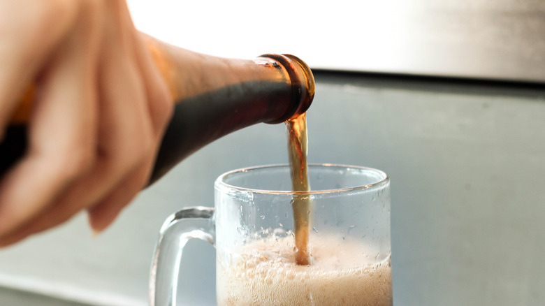 pouring root beer into glass