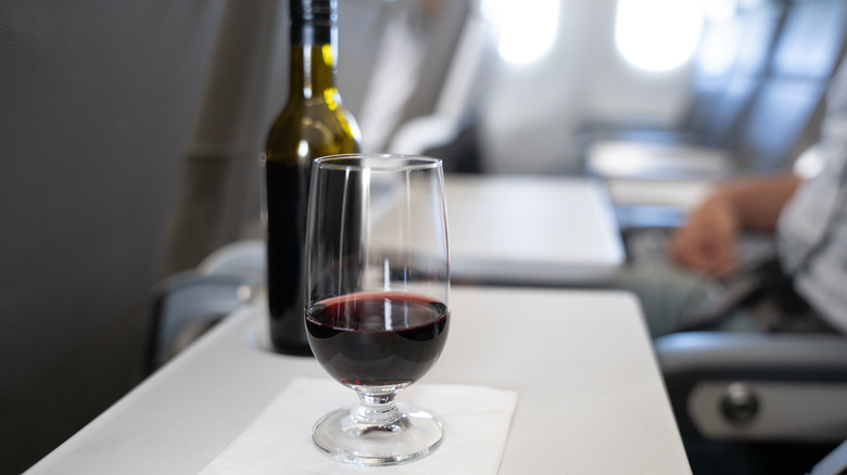 glass of red wine on plane tray table