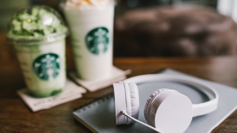 Headphones in front of Starbucks drinks
