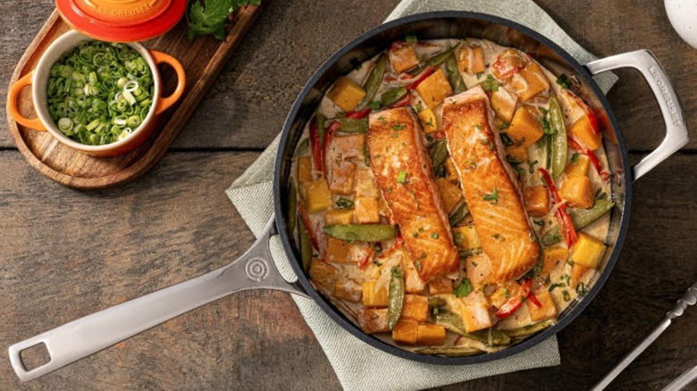 le creuset skillet with seared salmon and vegetables