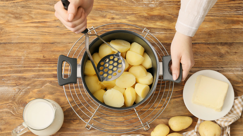 Person preparing mashed potatoes