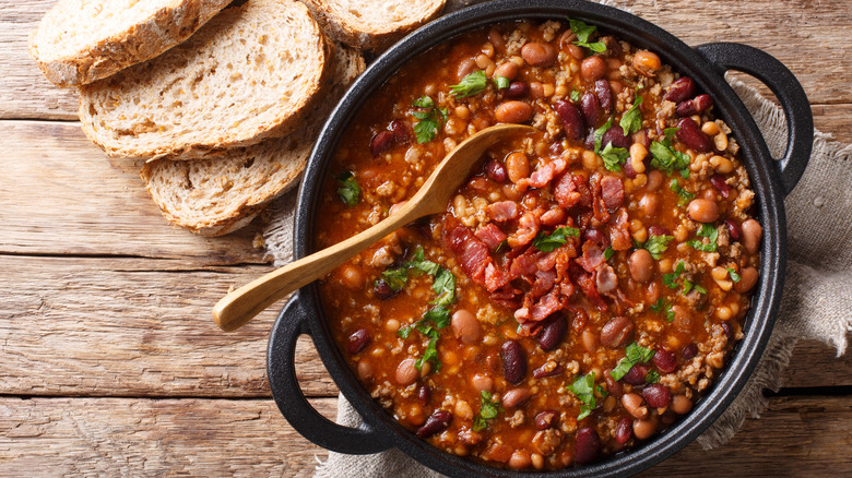 pot of beans cooking with sliced bread beside it