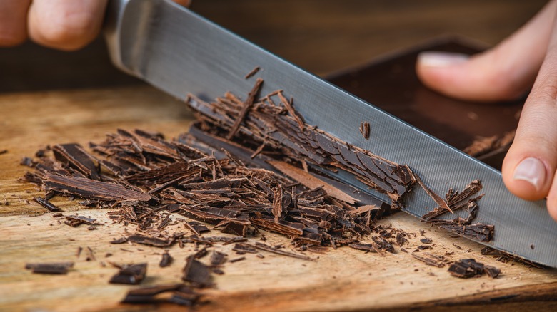 Knife cutting chocolate on cutting board