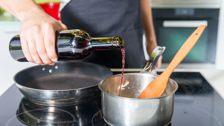 pouring red wine into a pot