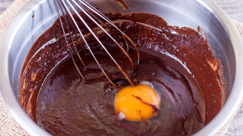 egg being whisked into brownie batter