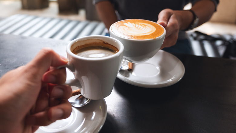 People drinking coffee in white mugs