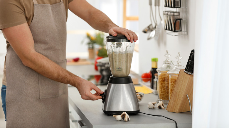 person prepares to blend food