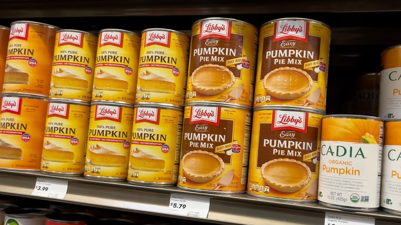 Several different brands of canned pumpkin on a store shelf