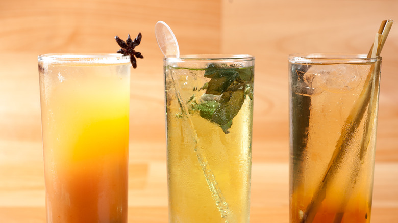 three colorful cocktails displayed with garnish