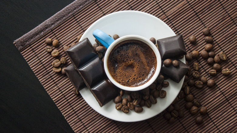 Coffee mug surrounded by chocolate 