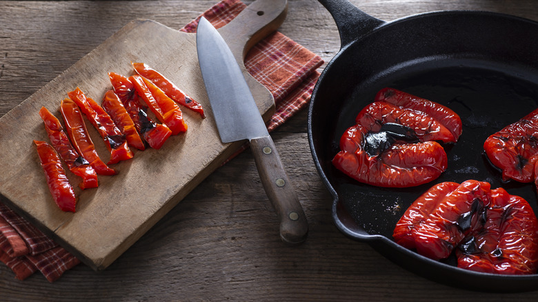 roasted red peppers in skillet and on cutting board