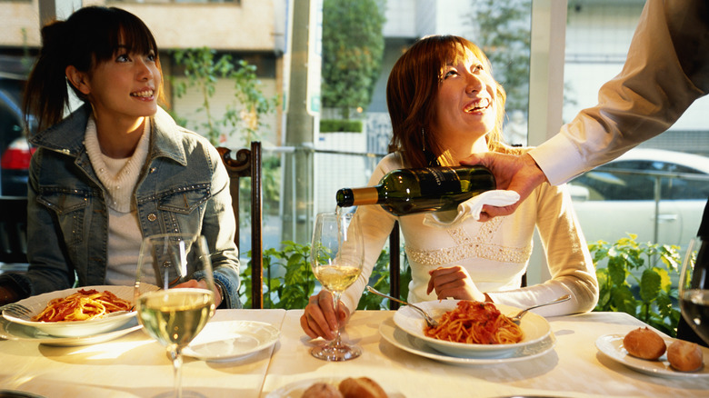 sommelier pouring wine for customers