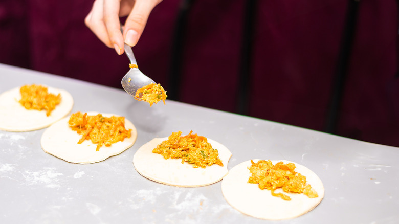 hand doling fillings onto dough