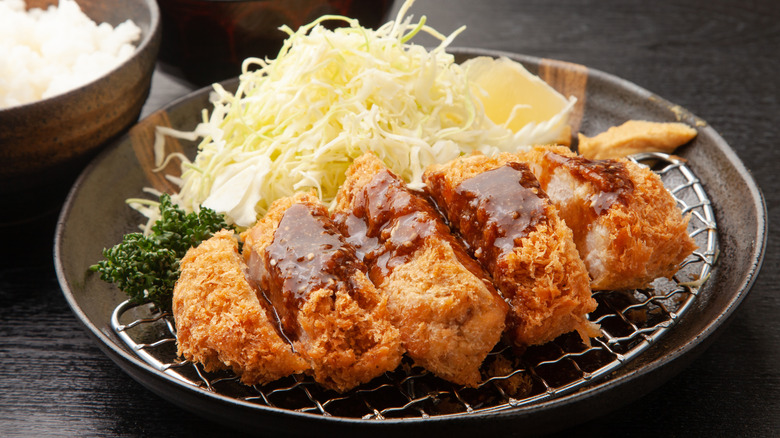 plate of pork katsu with sauce and cabbage