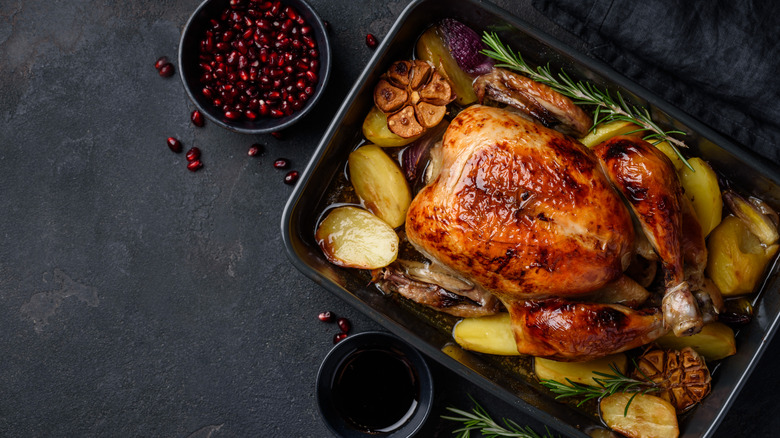 roast chicken surrounded by potatoes