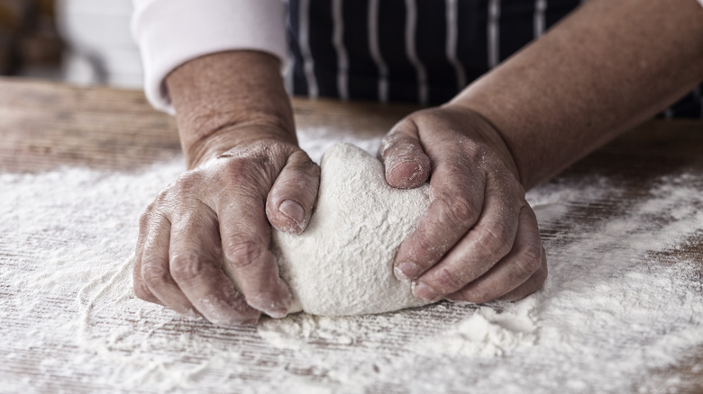 male chef kneading pizza dough