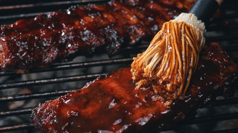 Brushing barbecue sauce on ribs