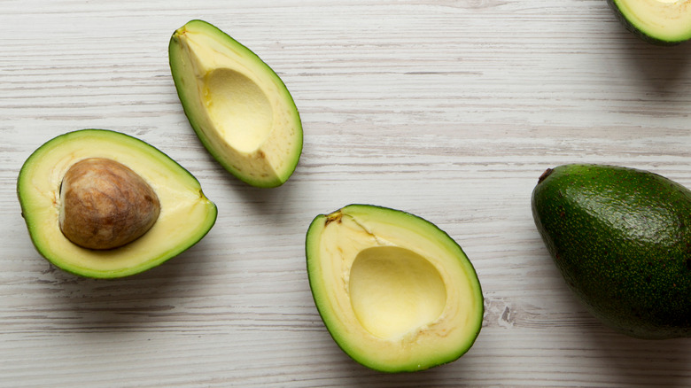 Avocado wedges on wood background