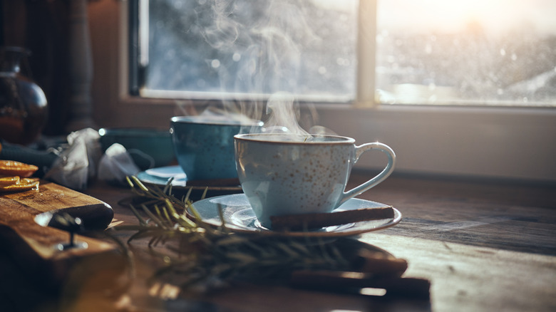 Steaming mug of tea by window
