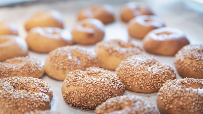 Sesame bagels on a parchment paper-lined pan