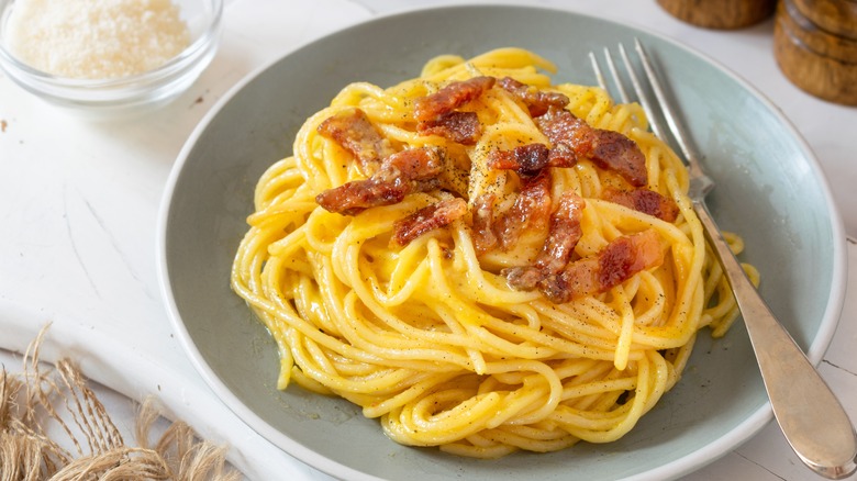 spaghetti carbonara with fork in bowl