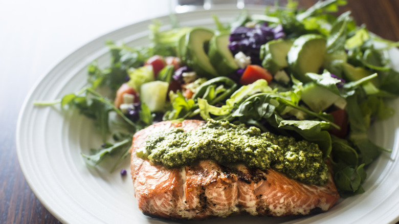 pesto over salmon with a salad