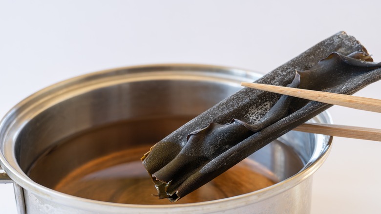 chopsticks adding kombu to dashi