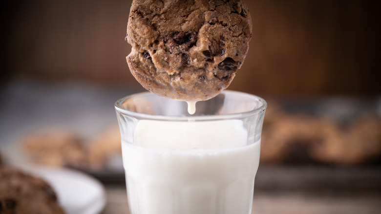 Cookie getting dunked into milk glass