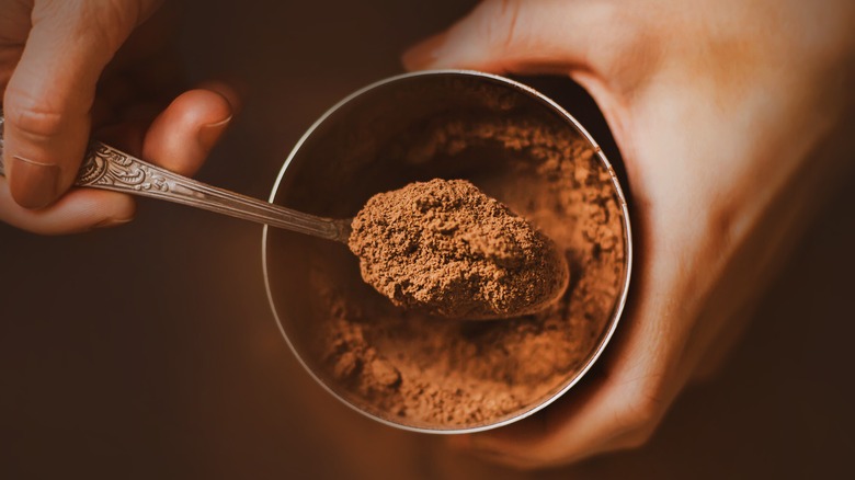 hands holding tin of cocoa powder