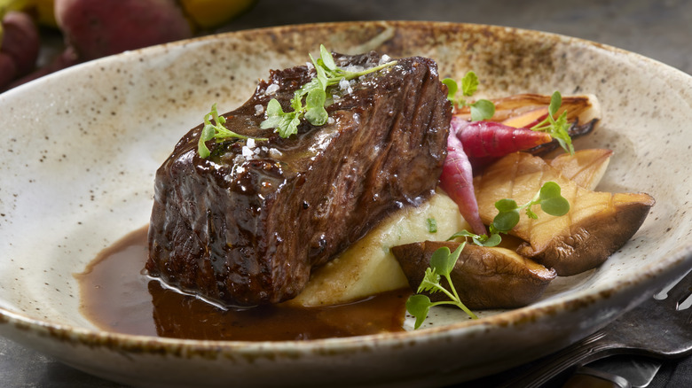 Steak and mash on a plate filled with juices